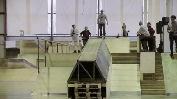 俄罗斯克拉斯诺亚尔斯克 - 2014年3月15日：轮滑运动员从一个跳板跳到另一个跳板。幻灯片。摄影师。溜冰场的比赛. — 图库视频影像