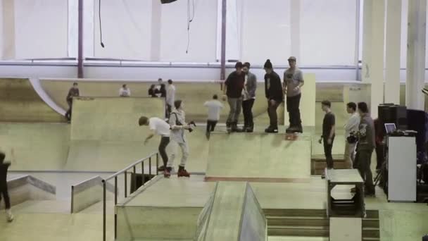 KRASNOYARSK, RUSSIA - MARCH 15, 2014: Young roller skater slip on fence, make flip. Cameraman. Competition in skatepark. Dangerous stunts — Stock Video