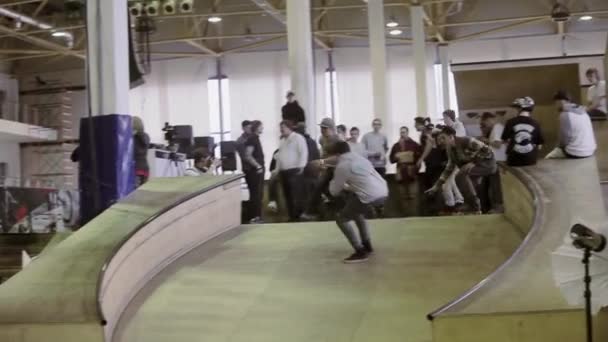 KRASNOYARSK, RUSIA - 15 DE MARZO DE 2014: Joven patinador hacer voltear, deslizarse en la valla curva. Camarógrafo. Gente. Competencia en skatepark . — Vídeos de Stock