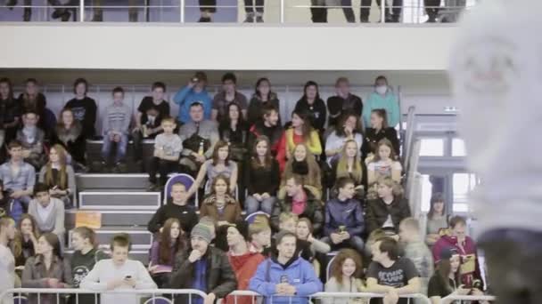 KRASNOYARSK, RUSIA - 15 DE MARZO DE 2014: Vista al público en tribuna sobre la competencia en skatepark. Camarógrafo. Detrás de la cerca. Multitud. Adolescentes — Vídeo de stock