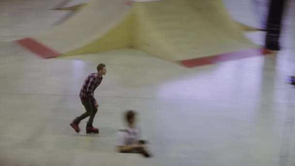 クラスノヤルスク、ロシア - 3月 15, 2014: 若いローラースケーターは、曲がった足のフェンスにスリップ.カメラマン。スケートパークでの競技。エクストリームスポーツ — ストック動画