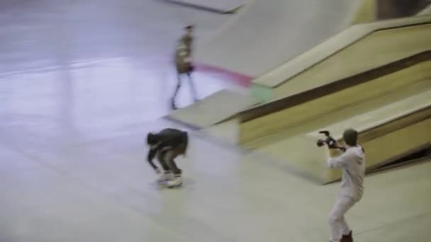 Krasnojarsk, Rusko-15. březen 2014: mladí bruslaři jedou na plot. Kameraman. Publikum. Soutěž na skateparku. Extrémní sport — Stock video