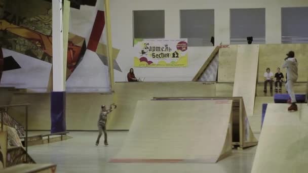 KRASNOYARSK, RUSSIE - 15 MARS 2014 : Un jeune patineur à roulettes effectue un saut en hauteur et un retournement extrême. Équilibre. Caméraman. Compétition en skatepark — Video