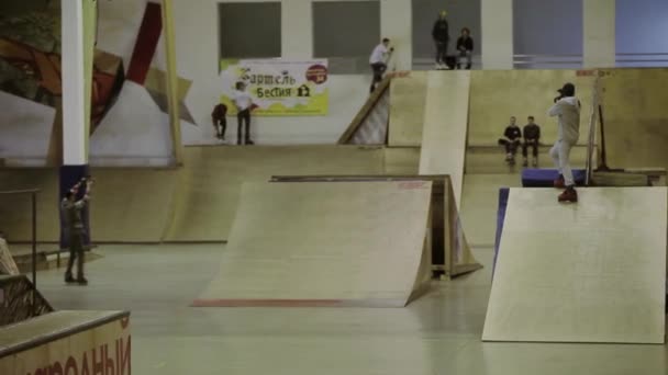 Krasnojarsk, Rusko-15. března 2014: mladý válečkový bruslař dělá vysoký skok, 360. Jedna noha na plotě. Soutěž na skateparku — Stock video