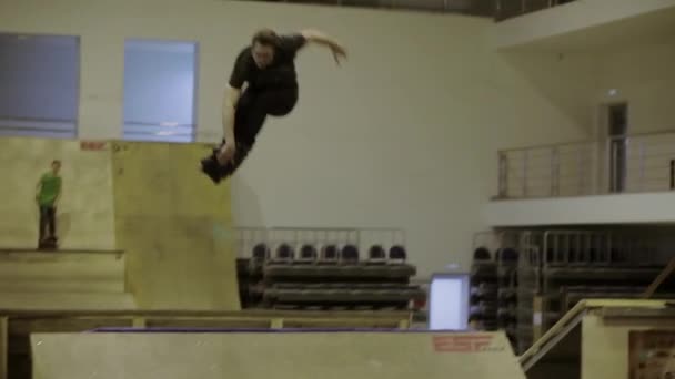 KRASNOYARSK, RUSIA - 15 DE MARZO DE 2014: Joven patinador de salto, agarrar las piernas rectas. Deslízate en la cerca. Gente. Competencia en skatepark — Vídeos de Stock