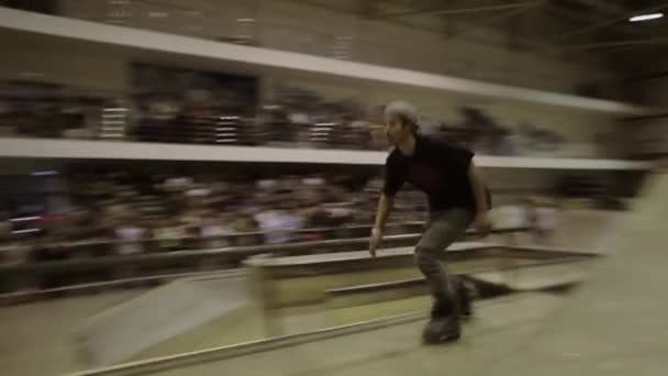 KRASNOYARSK, RÚSSIA - Março 15, 2014: Patinador de rolo em chapéu deslizar sobre cerca, vire. Público. Competição no parque de skate. Desporto extremo — Vídeo de Stock