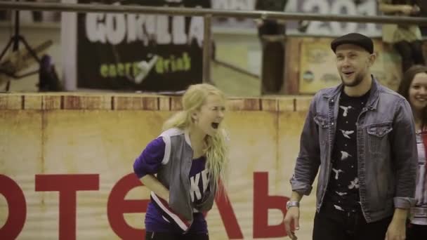 КРАСНОЯРСК, РОССИЯ - 15 марта 2014 года: Юная девушка громко кричит. Хозяин в шляпе говорит в микрофоне. Конкурс в скейтпарке. Эмоции — стоковое видео