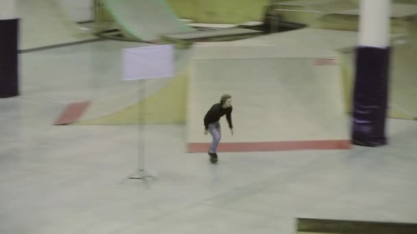 KRASNOYARSK, RUSSIA - 15 MARZO 2014: Salto con il pattino a rotelle, afferrare il piede in aria. Scivolare sulla recinzione. Cameraman. Competizione in skatepark. Stunt duro — Video Stock