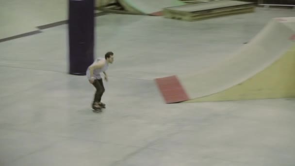 KRASNOYARSK, RUSIA - 15 DE MARZO DE 2014: Patinador de rodillo hacer 180 voltear, agarrar el pie. Cabalga en valla. Competición en skatepark. Público. Stunt. — Vídeos de Stock