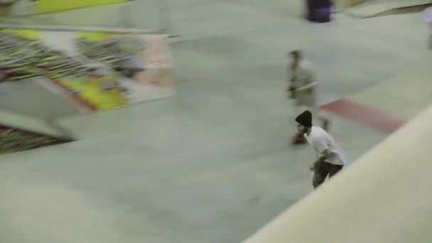 Krasnojarsk, Rusko-15. března 2014: kolečkové bruslař s vysokou rychlostí, skočte na Springboard. Soutěž na skateparku. Publikum — Stock video