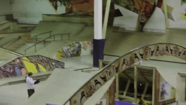 КРАСНОЯРСК, РОССИЯ - 15 МАРТА 2014: Роллер-фигурист делает экстремальные флипы в воздухе. Поскользнись на заборе на одной ноге. Конкурс в скейтпарке . — стоковое видео
