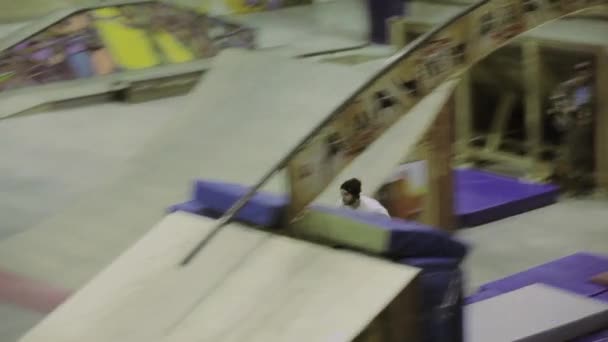クラスノヤルスク、ロシア - 3月 15, 2014: 帽子のローラースケーターは、高速でスプリングボードから飛び出します.スケートパークでの競技。観客. — ストック動画