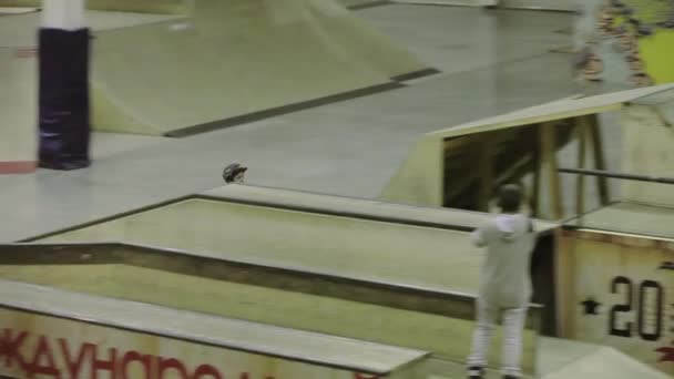 KRASNOYARSK, RUSIA - 15 DE MARZO DE 2014: Patinador de patines en casco hacer salto sin éxito en el trampolín. Derrama. Competencia en skatepark . — Vídeos de Stock