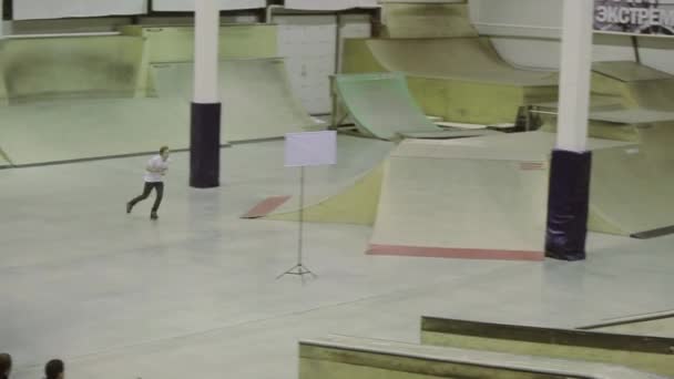 KRASNOYARSK, RUSIA - 15 DE MARZO DE 2014: El patinador hace un salto infructuoso en el trampolín. Competición en skatepark. Fracasando. Camarógrafo . — Vídeo de stock