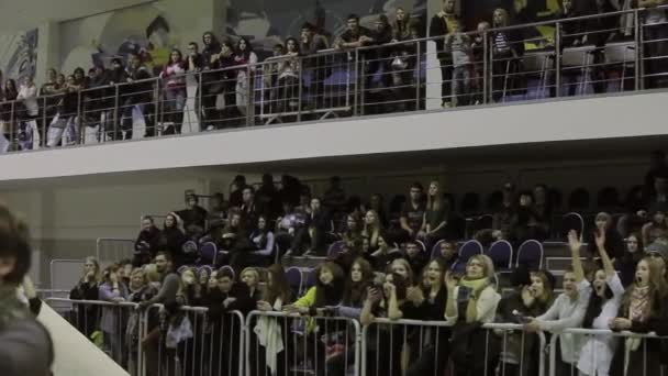 KRASNOYARSK, RUSIA - 15 DE MARZO DE 2014: Ver al público aplaudir en tribuna en competición en skatepark. Camarógrafo. Detrás de la cerca. Adolescentes — Vídeo de stock