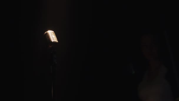 Schrubberin mit Wischmopp und Eimer spaziert über die Bühne. Mikrofon im Rampenlicht — Stockvideo