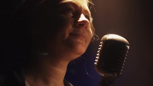 Scrubwoman in gloves start sing in vintage microphone on stage. Spotlight. — Stock Video