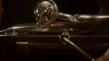 Erkekler müzik çalmak için gramofon mekanizmasını açarlar..