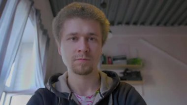 Adam kamerada yığınla para gösteriyor ve ikna edici bir şekilde başını sallıyor..