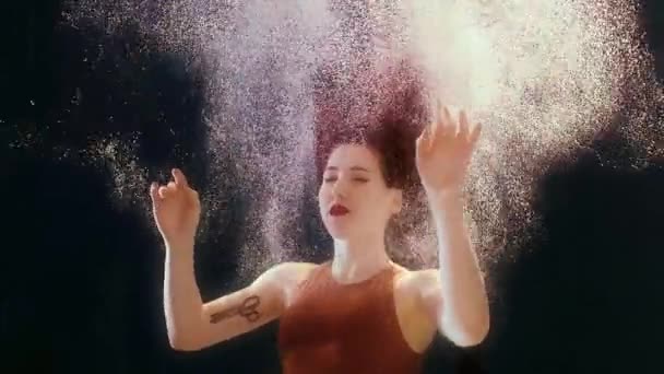 Vrouw in een badpak en een zwarte rok zwemt in het water, zwaaiende armen en benen — Stockvideo