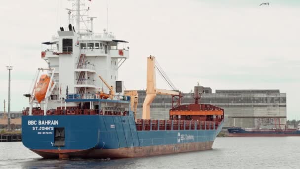 Cargo ship with containers and a crane departs from the pier. — Stock Video