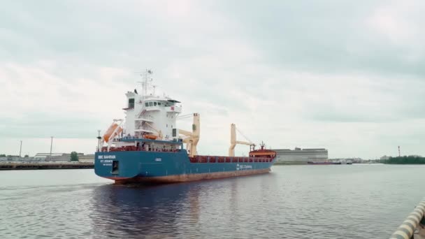 Cargo ship with containers and a crane departs from the pier. — Stock Video