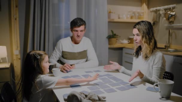 Familj pappa mamma och dotter spela brädspel vid bordet — Stockvideo