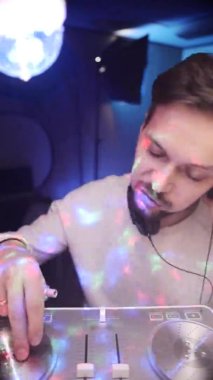 Disko topu ışıklandırmacısının olduğu odada kameraya bakıyor ve konuşuyor..