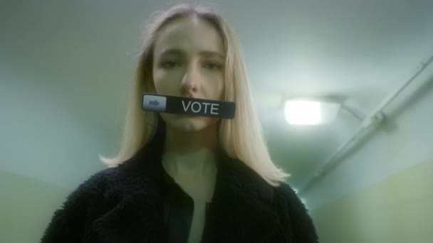Kobieta trzyma znak w ustach z napisem - Głosuj — Wideo stockowe