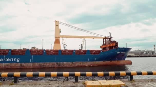 Buque de carga con contenedores y una grúa sale del muelle. — Vídeo de stock