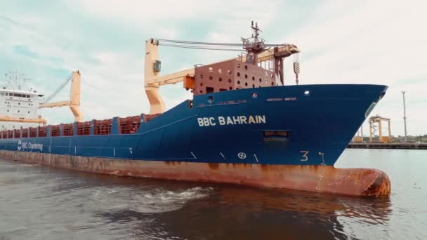 A cargo ship with containers and a crane departs from the pier. — Stock Video