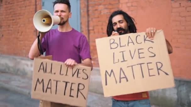 Twee blanke mannen protesteren op straat met megafoons en borden. — Stockvideo