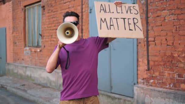 Blanke man protesteert op straat met megafoons en borden — Stockvideo