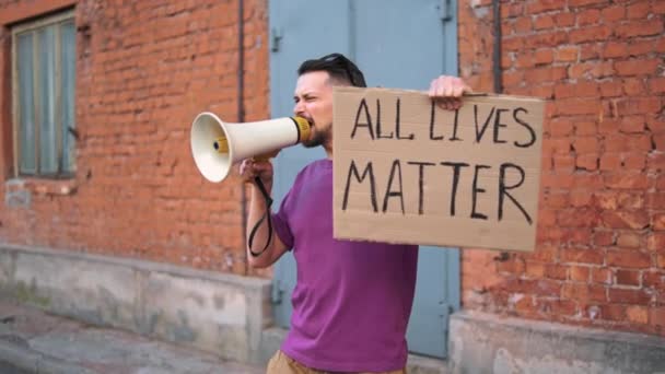 Hombre caucásico protestan en la calle con megáfonos y carteles — Vídeo de stock