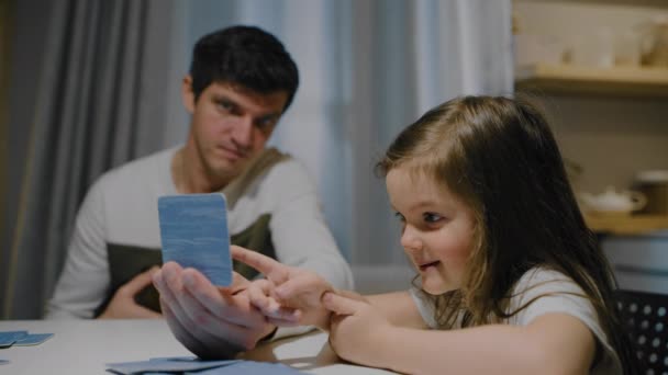 Padre e hija por la noche en la cocina jugar juegos de cartas de mesa. — Vídeo de stock