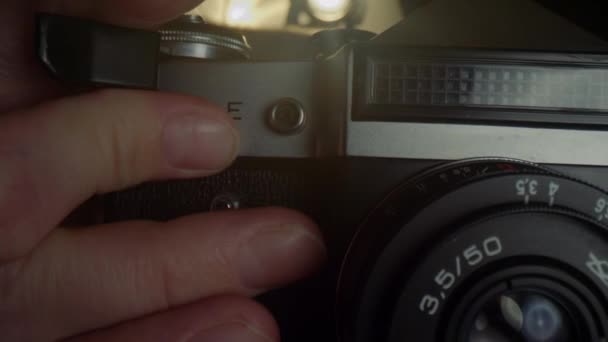 古い機械式カメラにフィルムを再読み込みする男性写真家の手. — ストック動画