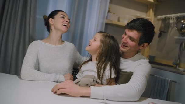 Щаслива біла родина мама тато і маленька дочка співають пісню на кухні — стокове відео
