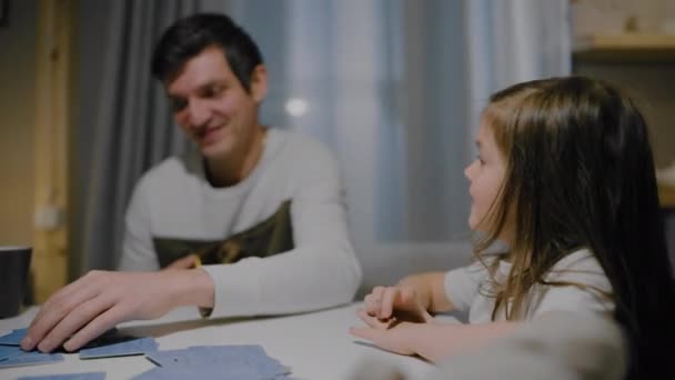 Padre e hija por la noche en la cocina jugar juegos de cartas de mesa. — Vídeo de stock