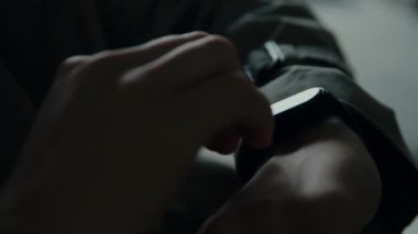 Yakın çekim erkek elleri eldeki akıllı bir elektronik saati kontrol eder.