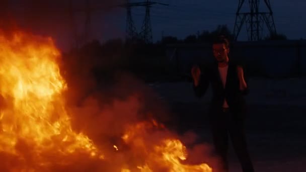 男は頭をつかむ、彼は火の中で焼かれた車のために非常に動揺している. — ストック動画