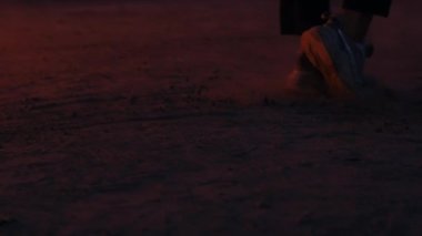 Yanan bir arabanın arka planında ay yürüyüşü yapan adam.