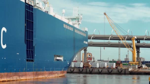 Frachtschiff mit Containern segelt mit Kran und Brücke vom Anleger weg. — Stockvideo