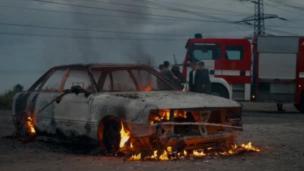 Fire engine standing next to a completely burned-out car. — Stock Video