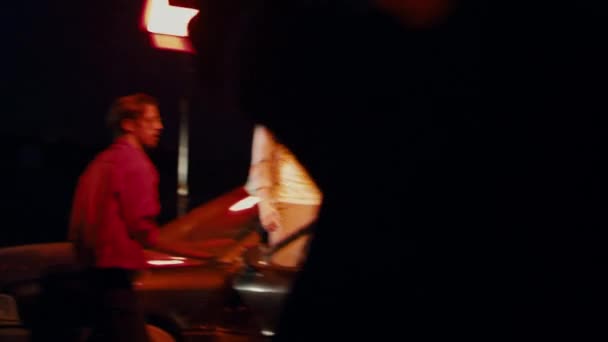 Twee mannen in een zonnebril dansen krachtig buiten de auto op straat 's nachts — Stockvideo