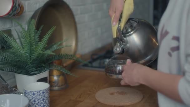 Uma mulher derrama água fervente quente em uma grande caneca com chá fabricado. — Vídeo de Stock