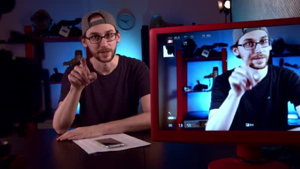 Blogueur avec des lunettes parle à la caméra vidéo, en ajustant la mise au point sur l'objectif — Video