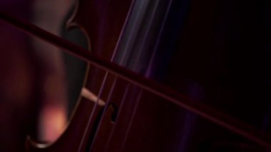 Çello çalan bir adamın elinin yakın çekimi..