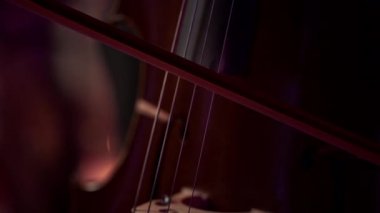 Çello çalan bir adamın elinin yakın çekimi..