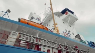 Büyük kargo gemisi rıhtımda duruyor ve yükün yüklenmesini bekliyor..