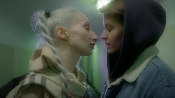 Två flickor kysser passionerat i gångtunneln. — Stockvideo